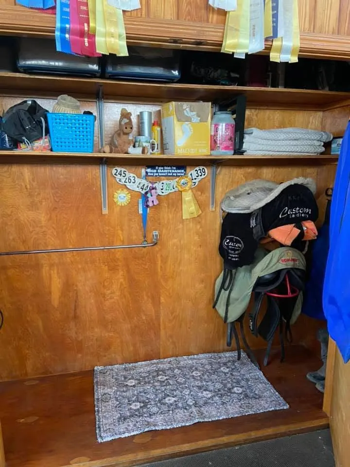 A tidy double-door tack locker at Avastar, hung with saddles and ribbons